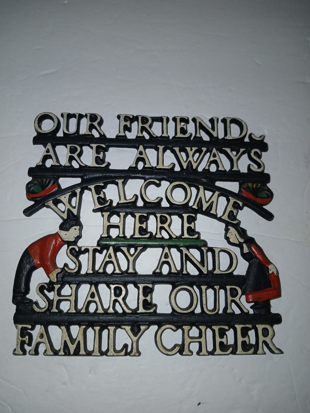 Vintage cast iron wall plaque or trivet featuring decorative text & figures
